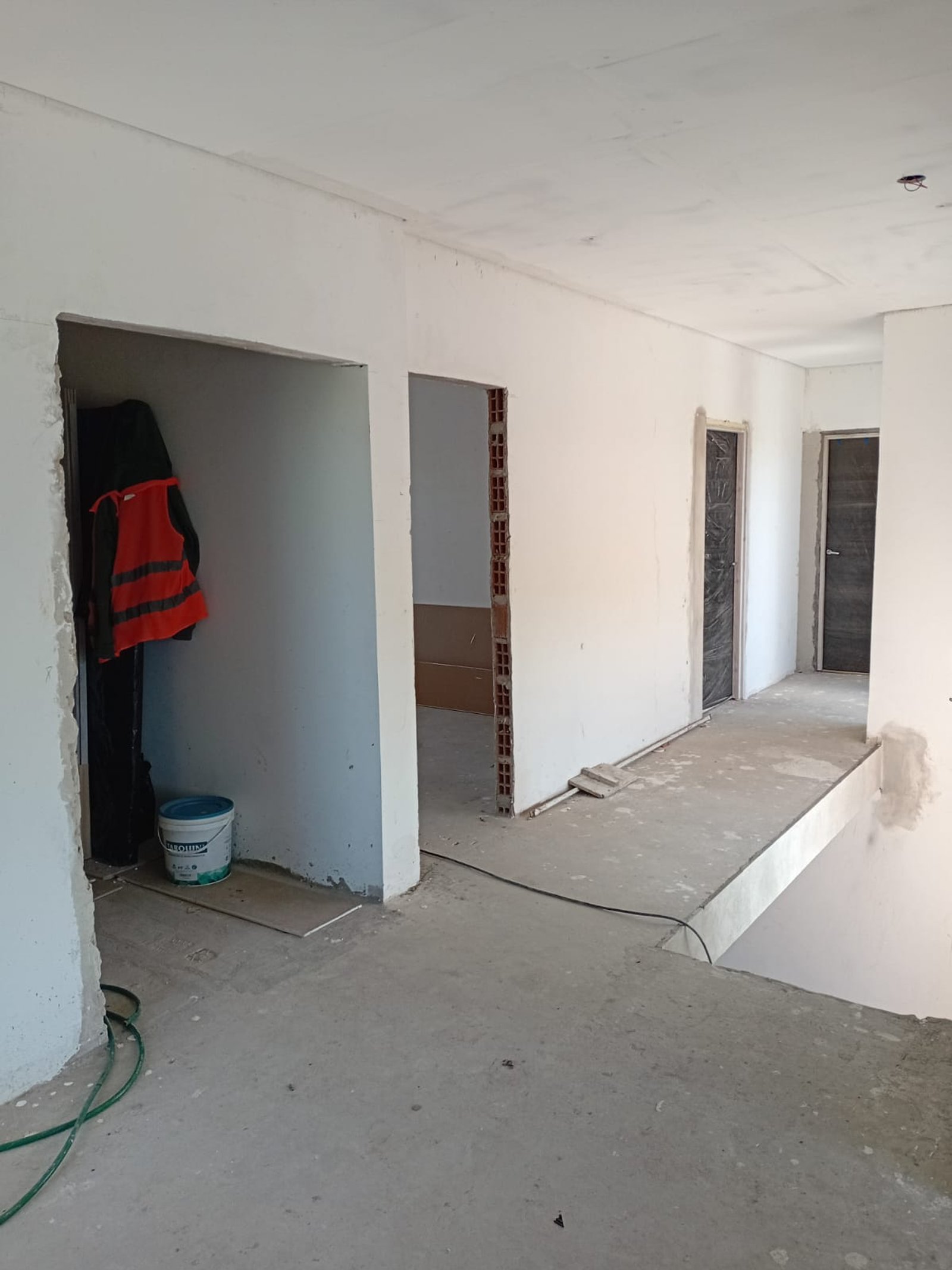 Interior de obra, piso de cemento, paredes blancas, rampa — proyecto Casa en Pueblos del Plata, por Arquitecto Guido Niccoli, en Guillermo Enrique Hudson